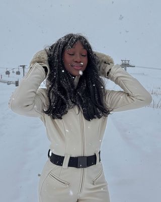 Emmanuelle Koffi wears a cream snow suit by Goldbergh while in Val-d'Isère, France.