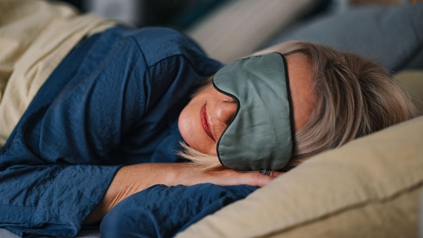 A woman sleeping on her side wearing an eye mask