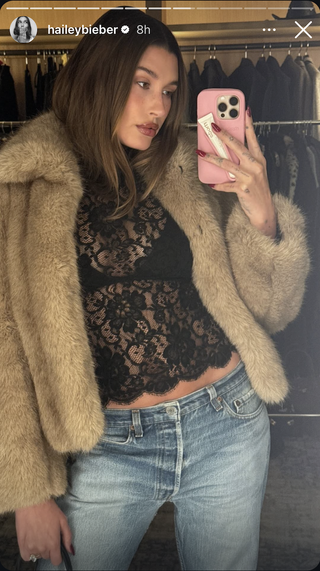 hailey bieber wears a fur coat and black lace top that showed her bra