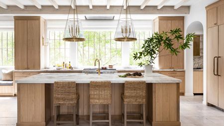 A white oak kitchen with marble countertops and brass accents