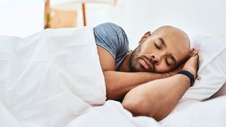 Man sleeping wearing Fitbit Charge 4