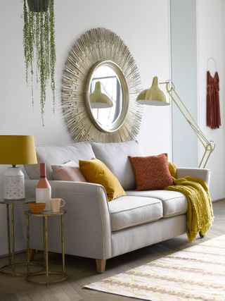living room with neutral scheme and yellow and red cushions by furniture village