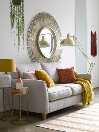 Yellow living room with neutral scheme and yellow and red cushions by furniture village