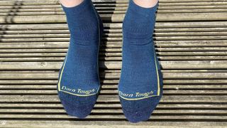 The reviewer wearing the Darn Tough Quarter Midweight Hiking Sock with Cushion while standing on some wooden decking