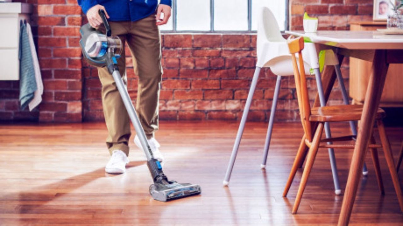 the Hoover ONEPWR Pet Max vacuum being used on hardwood floors around chairs