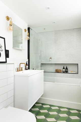 white bathroom with bath shower tub, green graphic tiled floor, glass shower screen