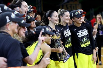Seattle Storm players pose with WNBA Championship trophy.