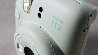 A mint green Fujifilm Instax mini 12 instant camera