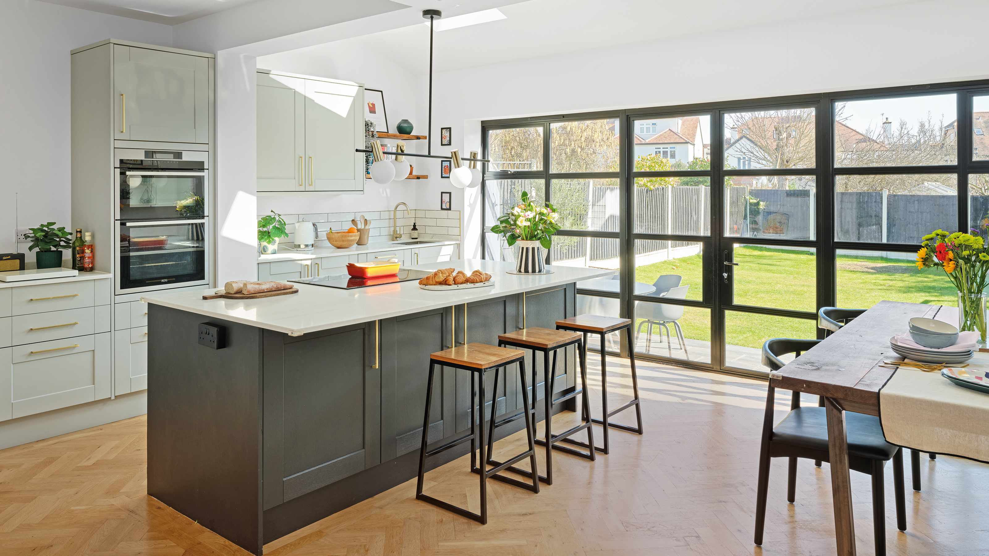large neutral kitchen with kitchen island and breakfast bar, skylight and large room-width patio doors