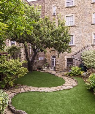 a stone path curving down a sloping garden