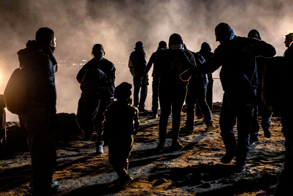 Migrants try to escape tear gas in Tijuana, Mexico, on New Year&amp;#039;s Day