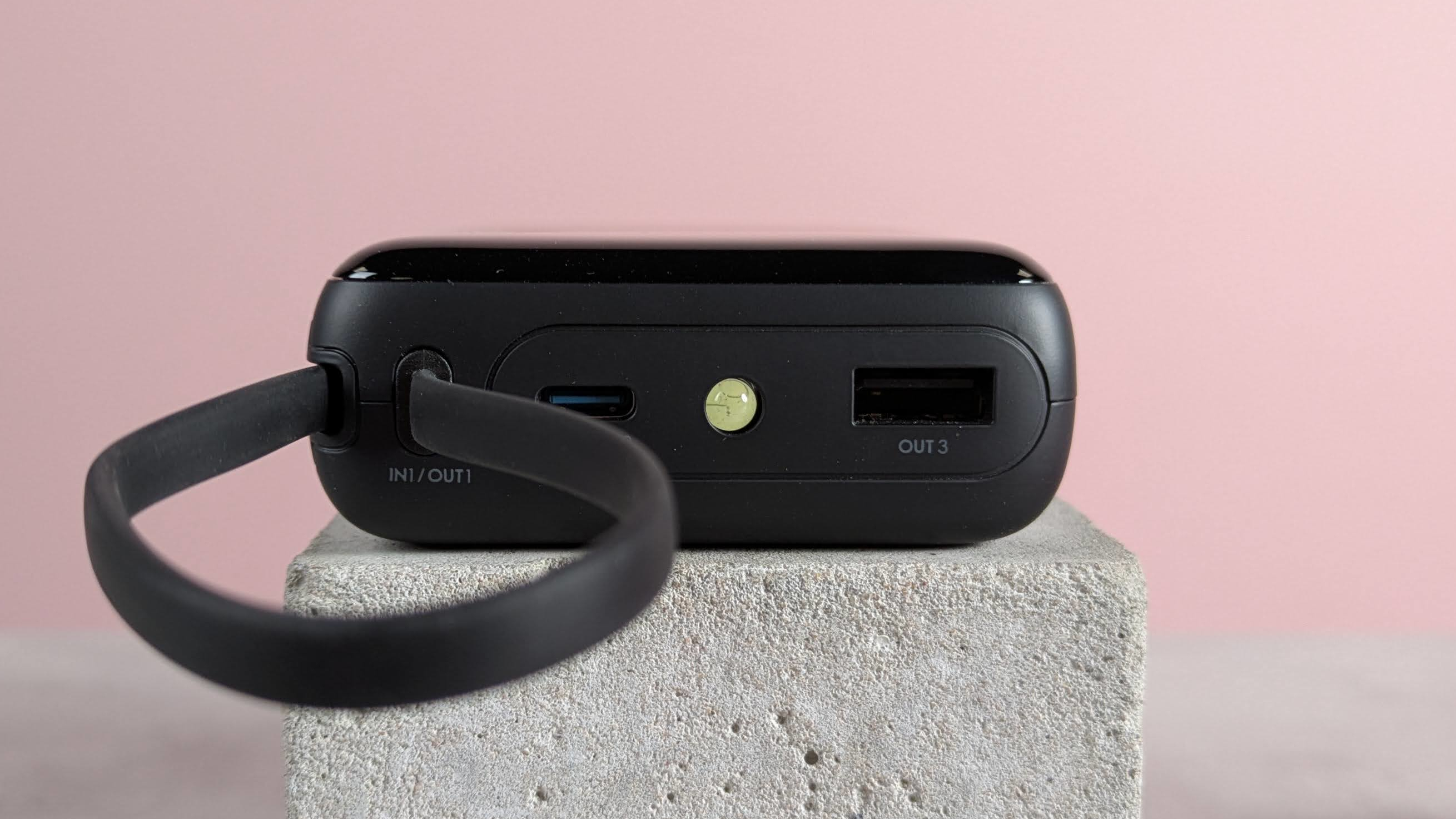Close-up of ports on INIU P51L-E1 Power Bank, on block on desk with pink background