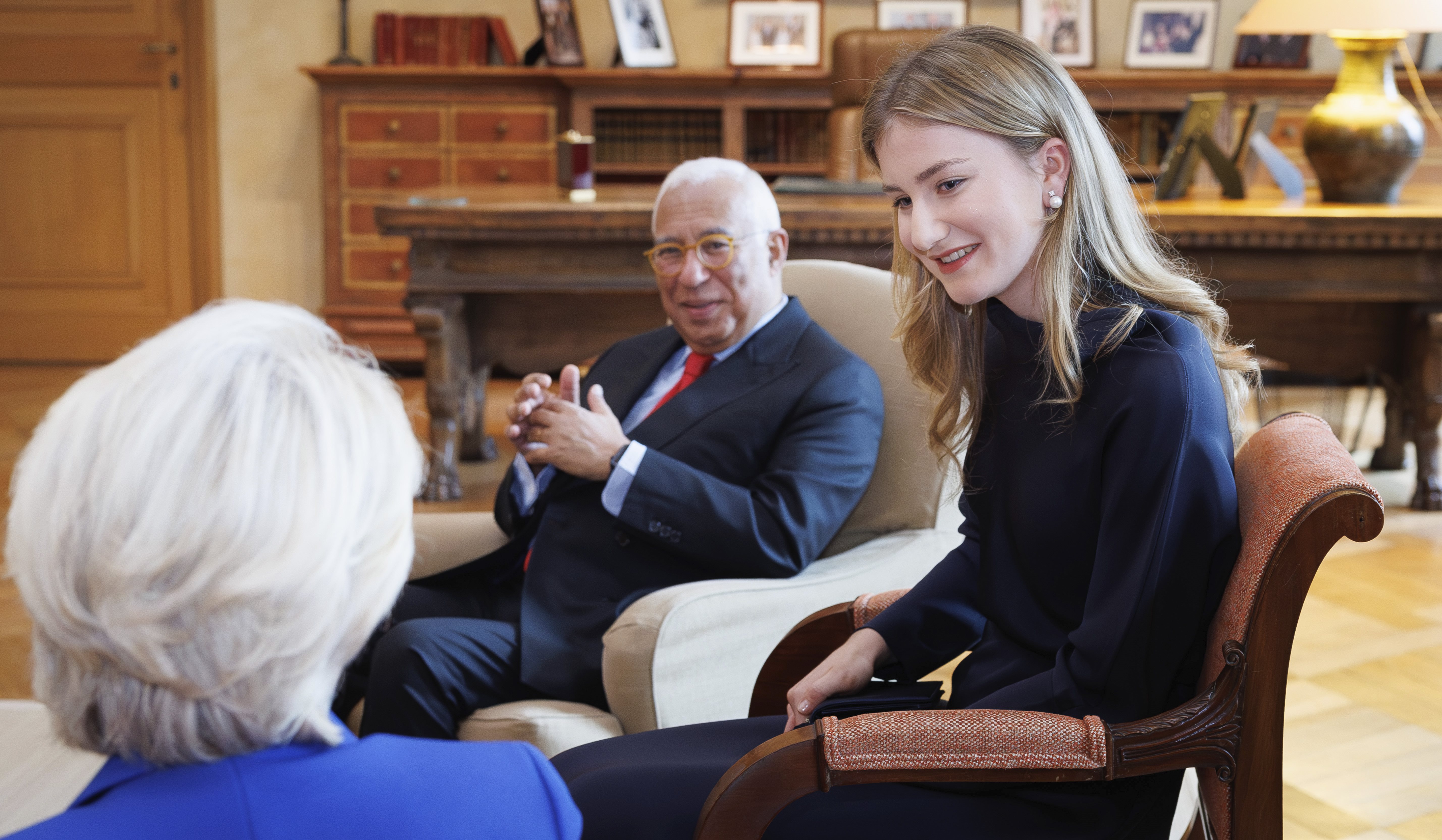 Princess Elisabeth wearing a blue dress talking to a woman sitting in a chair