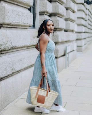 Summer rainy day outfits: @nnennaechem wears a black maxi dress and handbag