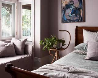 A bedroom with lilac bed sheets