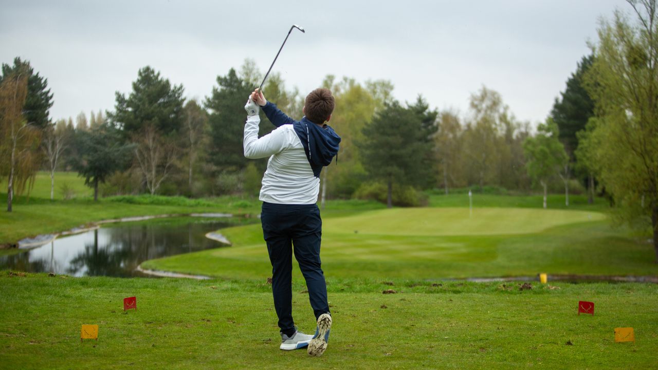 Sam Tremlett hits a tee shot on a par-3 hole