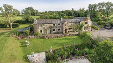 A large stone mansion with a large backyard