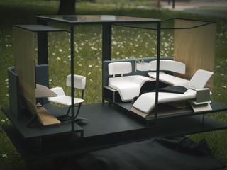 View of an ecosystem designed by Jude Fan featuring a black frame, white seating and black flooring in a grassy area