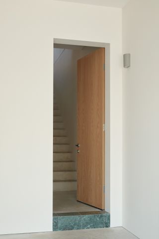 Wooden door opening to a staircase