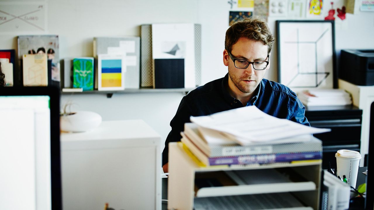 A small-business owner looks over paperwork in his office.