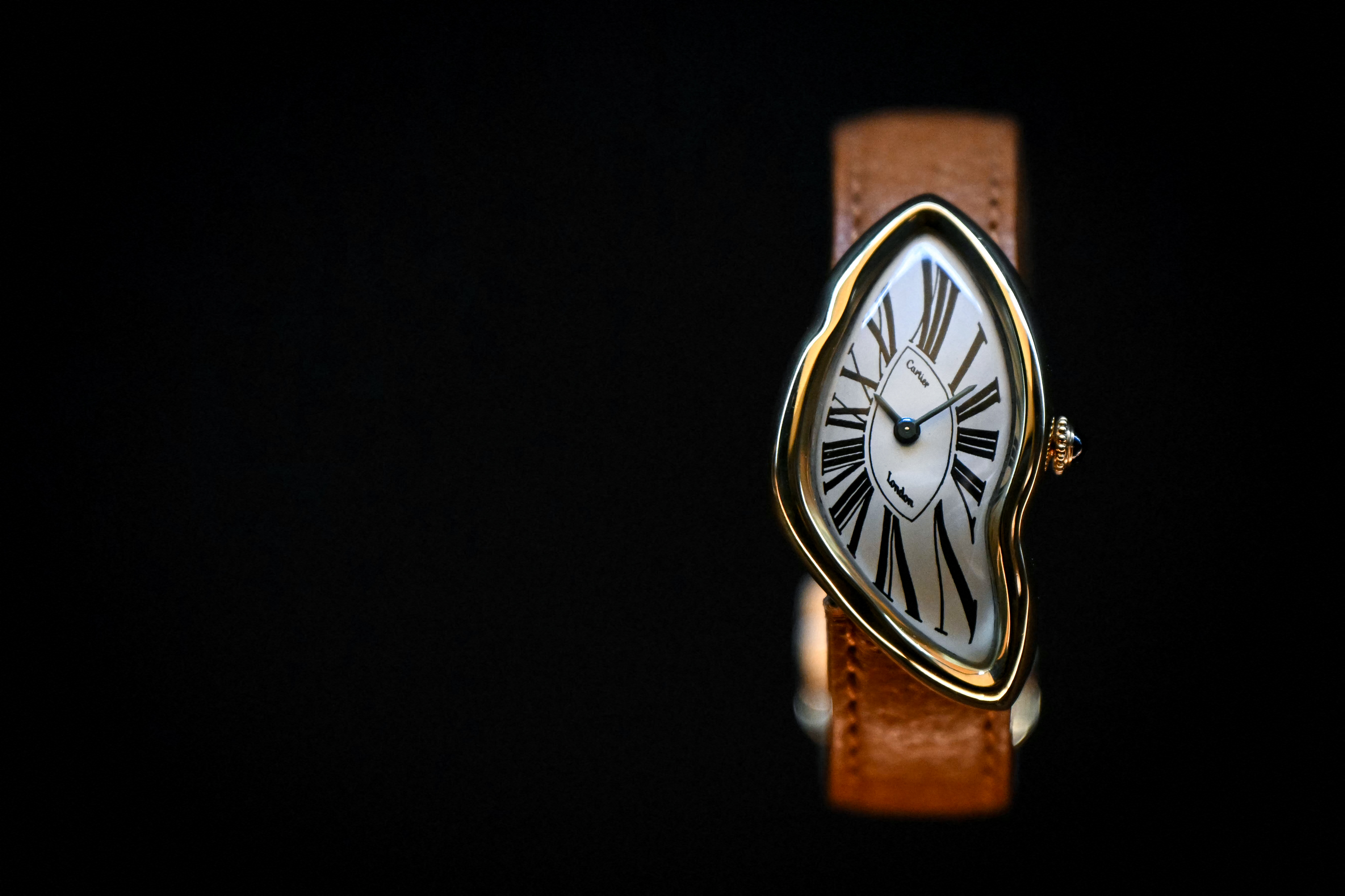 Cartier Crash watch, on a light brown leather strap, displayed on a black background