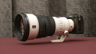 Sony FE 300mm F2.8 GM OSS lens on a red table 