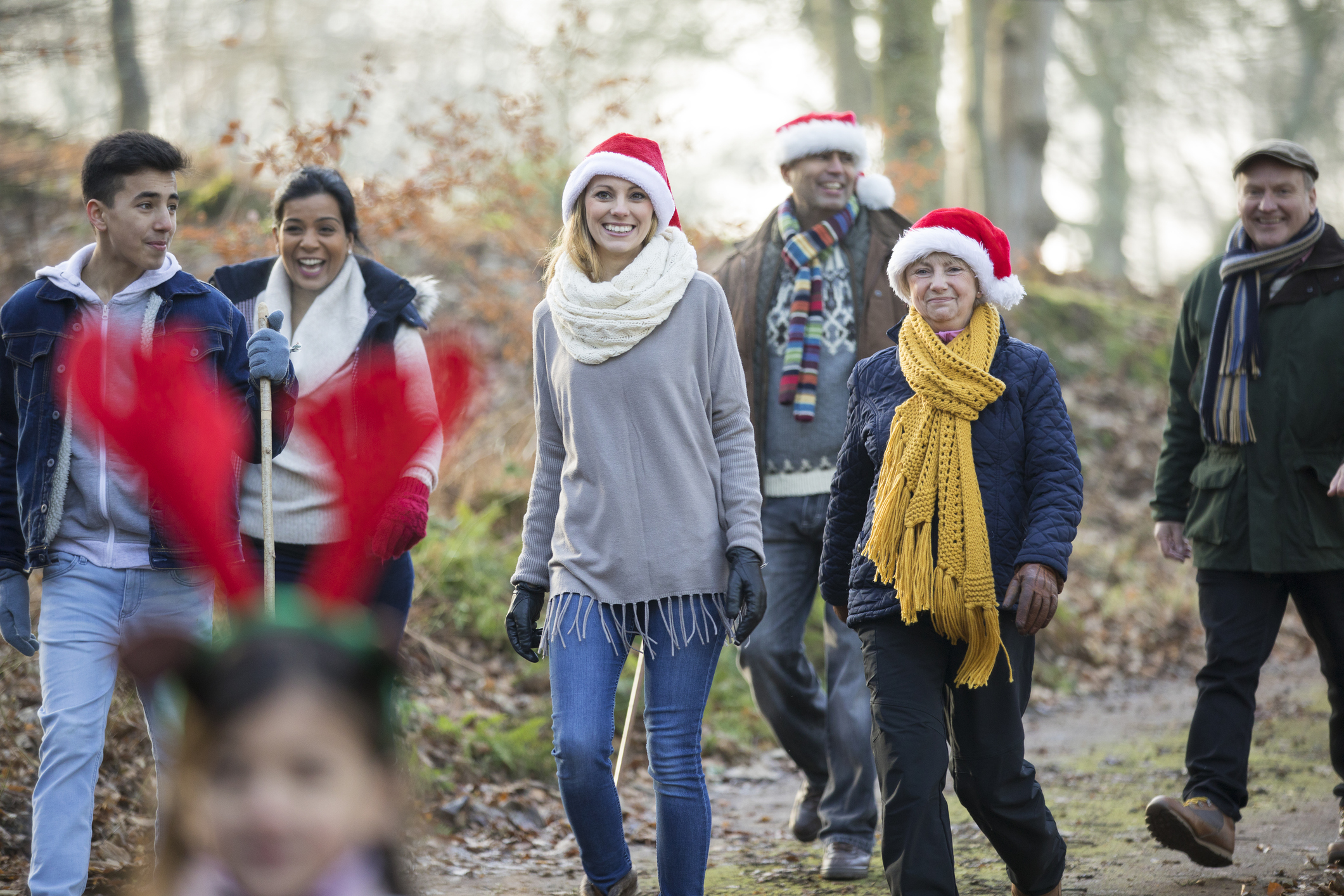 A family walk through the woods together in winter.