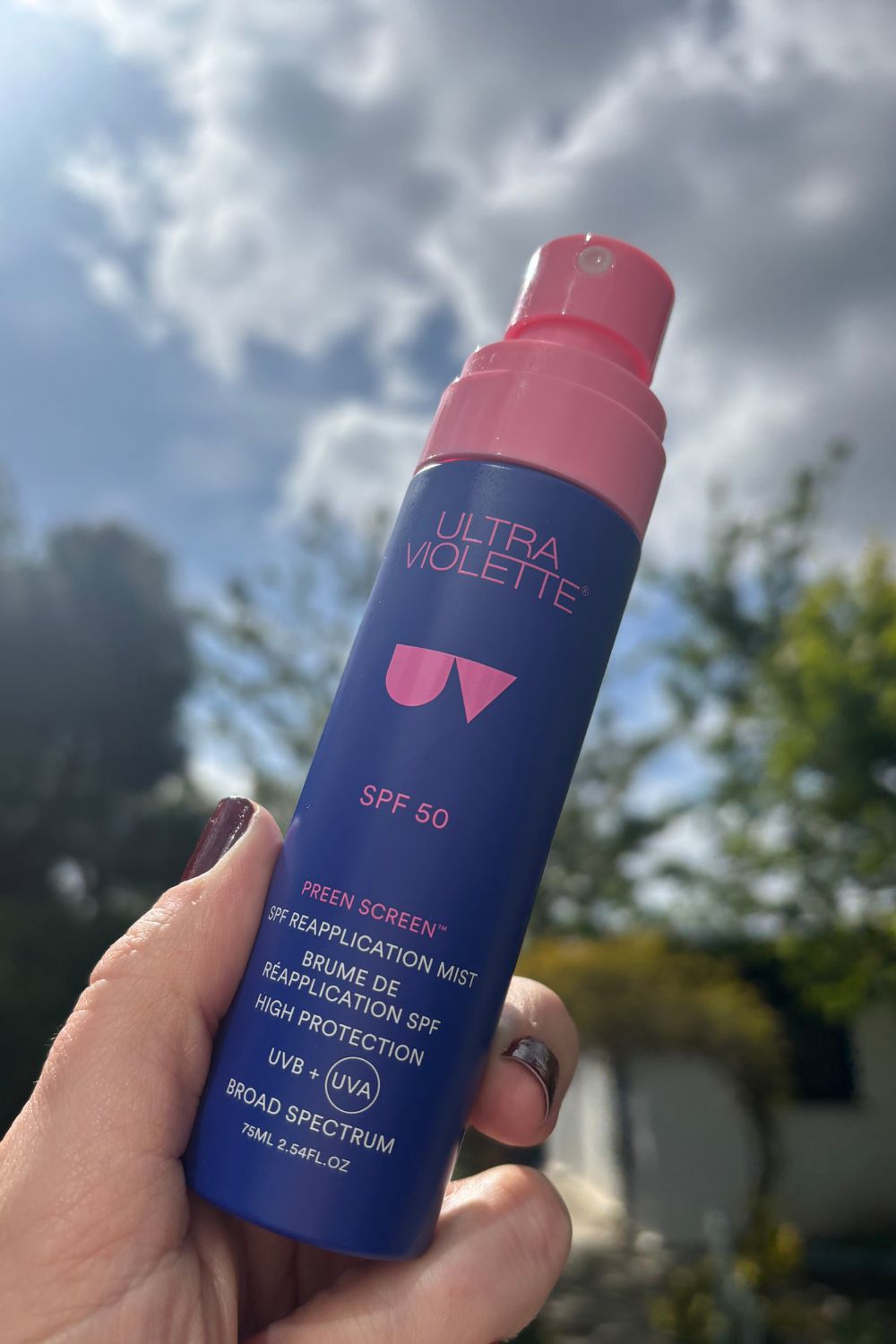 a hand holding a bottle of ultra violette preen screen reapplication mist