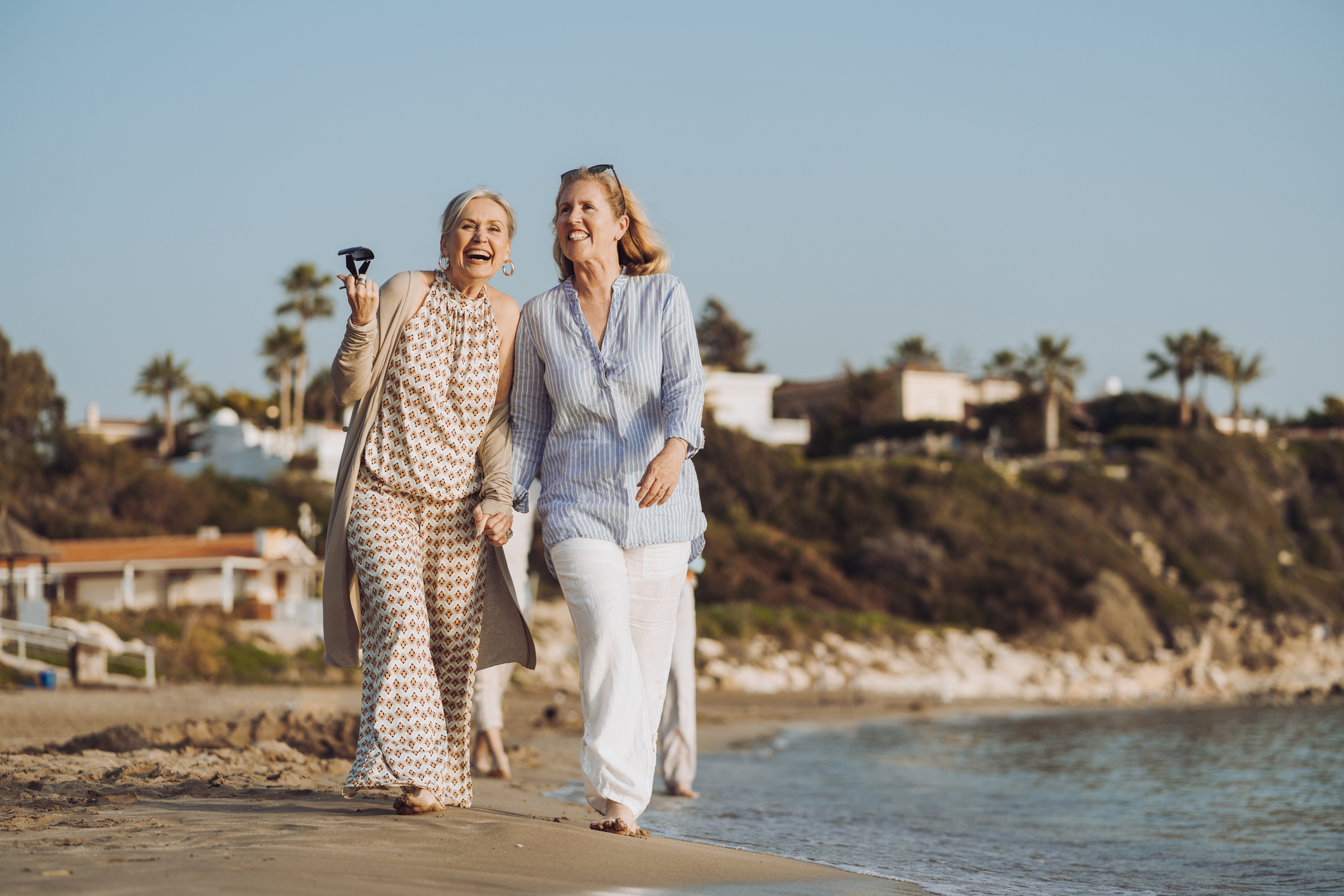 Happy friends on vacation, walking by the sea