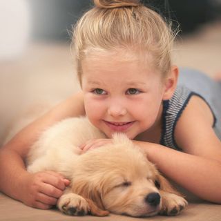 kid wearing blue tshirt and with dog