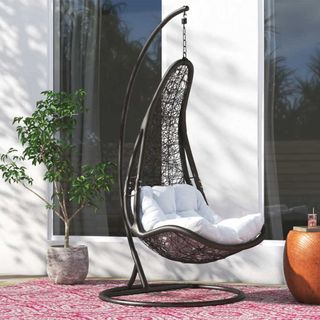 black woven hanging egg chair as a suggested quiet luxury garden trend accessory
