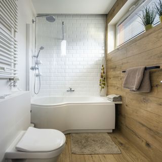 a modern bathroom with a white shower and tub and wood walls