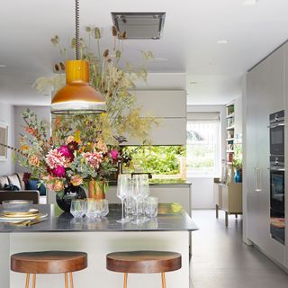 Kitchen with flower in pot and chairs