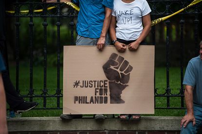 A protester holds a sign reading, "Justice for Philando"