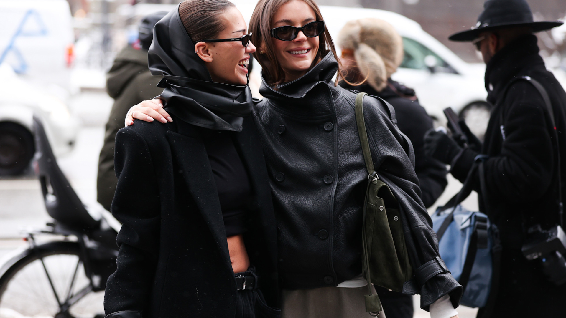 two copenhagen fashion week attendees smiling wearing sunglasses