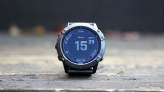 Image shows the Garmin Fenix 6X Pro Solar watch resting on a wooden surface