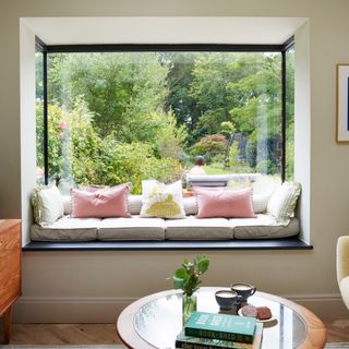 large cushioned window seat and a mid-century style coffee table