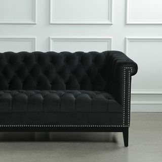 black velvet sofa with leather and white panel wall