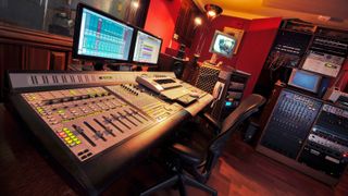 Recording studio desk with computer screens and studio monitors