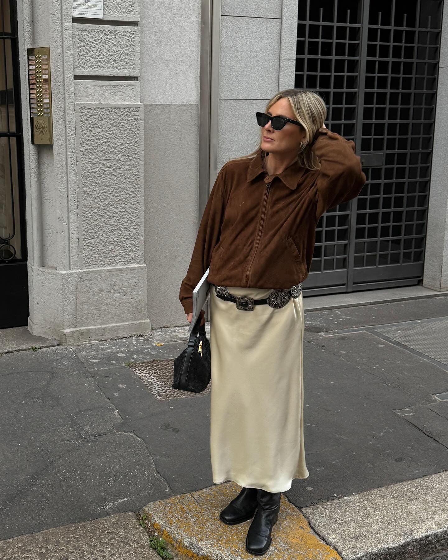 Influencer Lucy Williams wearing a brown suede jacket and cream slip dress