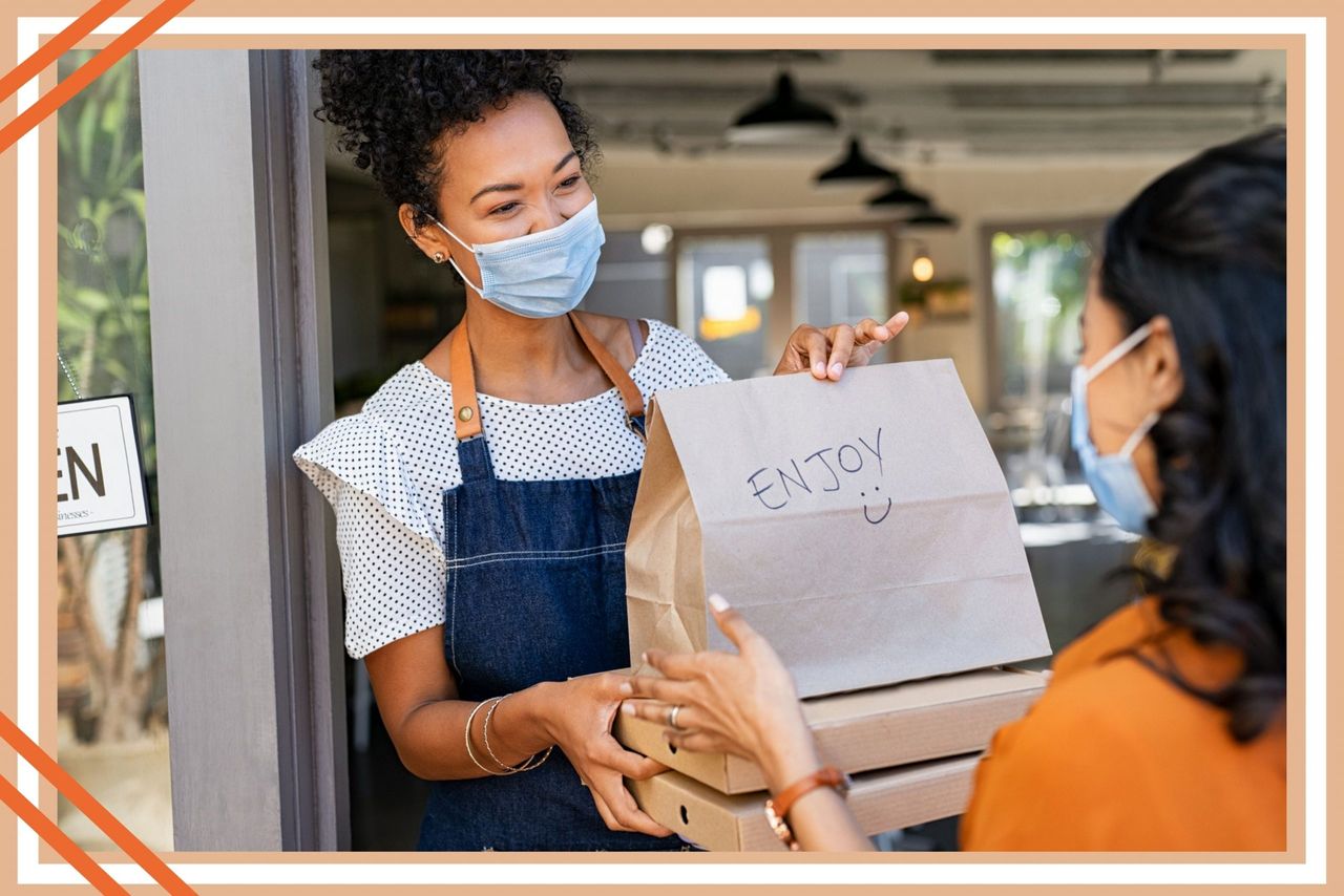 A woman collecting her takeaway food from another woman