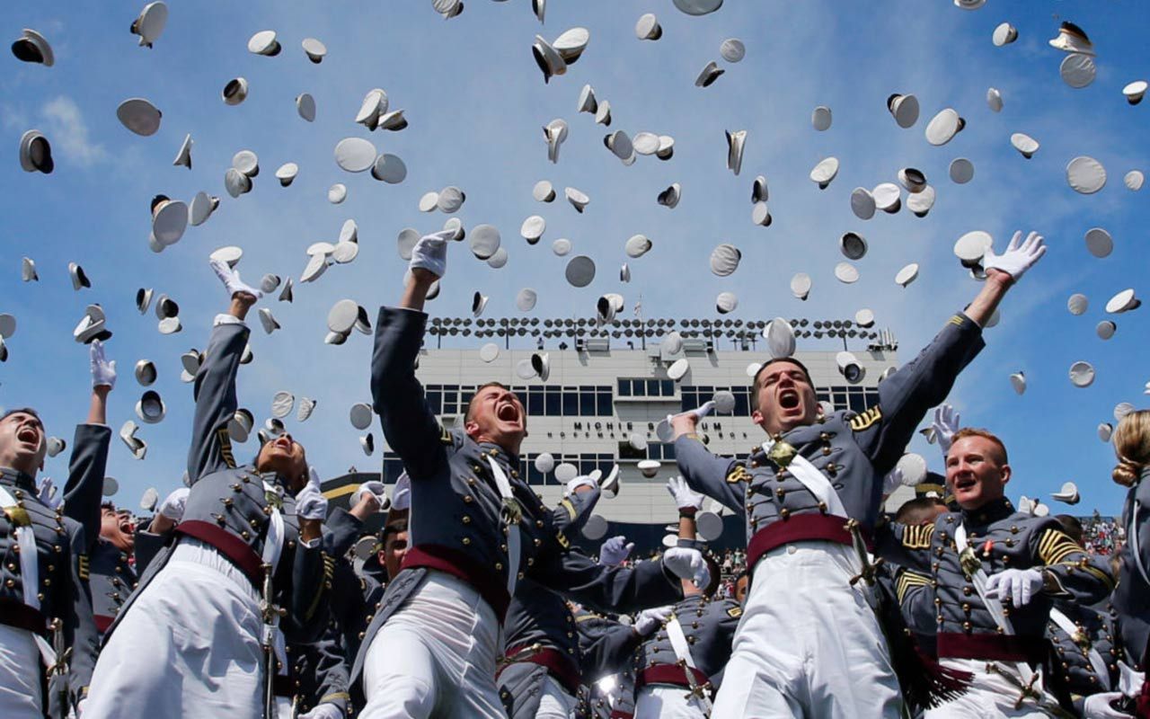 picture of West Point cadets at graduation throwing their hats into the air