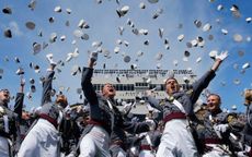 picture of West Point cadets at graduation throwing their hats into the air