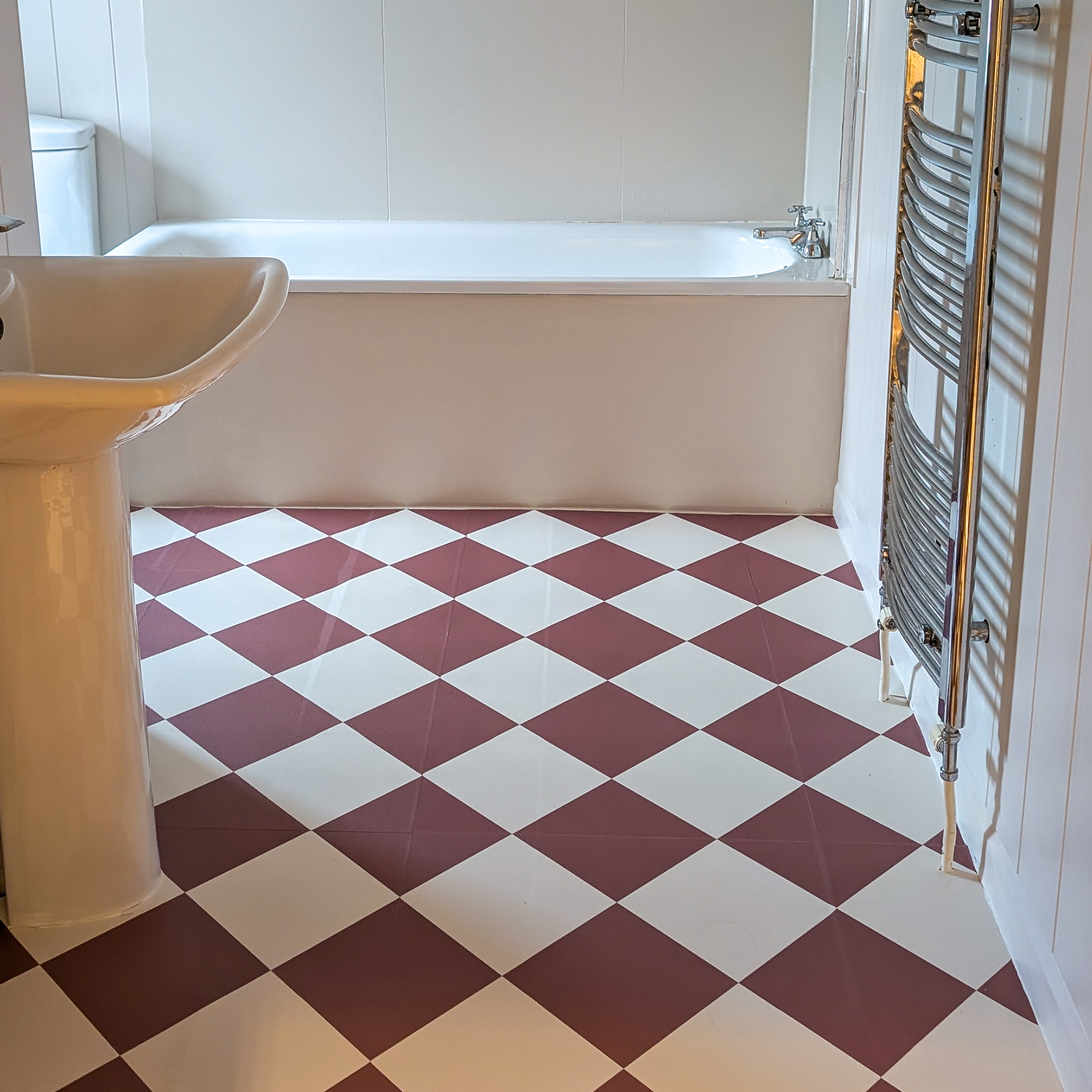 Beige bathroom with terracotta and white checkerboard vinyl floor tiles