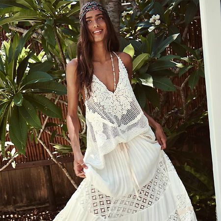 Models wear FP. One wears a white pants set. The next wears a white skirt set, and the last one wears lightweight drawstring denim and a black top. 