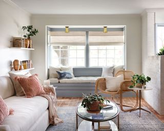 a clean stylish living room with an alcove sofa, a sofa, a chair and two tables, by joanna gaines