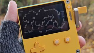 Hand holding Playdate handheld with Echo: The Oracle’s Soul gameplay on screen