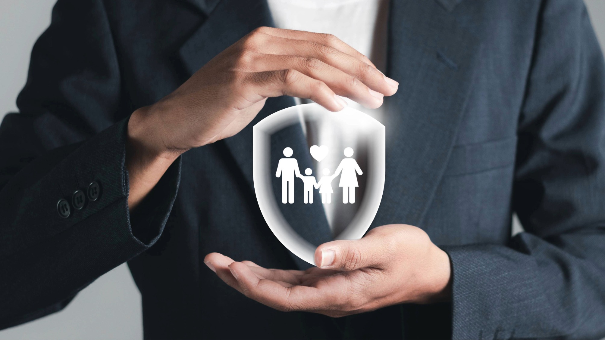 Close up of businessman's hands cradling a life insurance icon