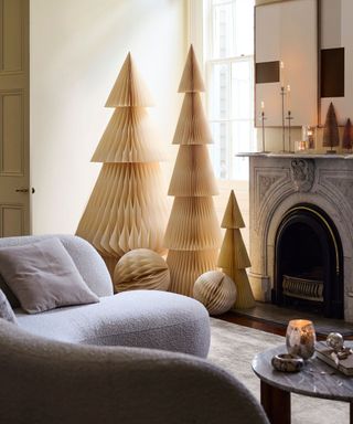 grey living room with a marble fireplace and paper honeycomb christmas trees