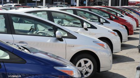 A row of Toyota Prius models on a car dealership’s forecourt